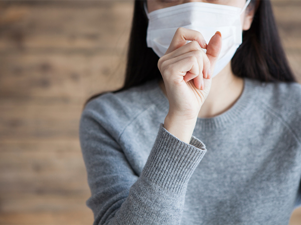 【画像】マスクをした女性が咳をしている